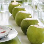 centro de mesa con manzanas que son velas