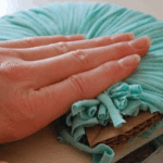 Cortando el pompón de trapillo con cuidado.