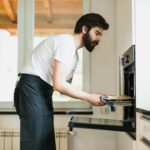 Bearded man with an apron baking pastries in the kitchen