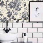 Mirror next to poster and plant in white and black bathroom inte