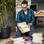 Millennial man organizing his book collections