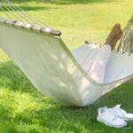 Black woman lying in hammock in a garden