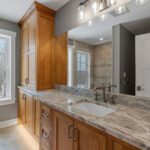 The elegant bathroom features luxurious granite countertops and sinks