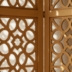 Close-up detail of a decorative wooden folding screen in a Mediterranean home, warm oak panels with