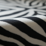 Close-up detail of luxury velvet fabric with zebra stripe pattern in black and white, showing the ri