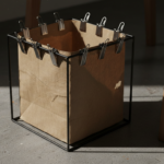 Close-up macro shot of a designer clip-style wastepaper basket, similar to Hommin’s famous design, w