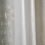 Close-up of shower curtain fabric textures, showing three different materials side by side: polyeste