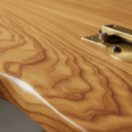 Extreme close-up macro photo of a high-end iroko wooden tabletop showing rich natural wood grain tex