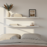 Minimalist floating wall shelves in a small bedroom above the bed headboard, displaying a few books,