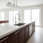 Modern elegant kitchen with quartz countertop, chrome monomando faucet with high spout over stainles