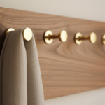 Detailed close-up of brass round hooks on a walnut wood wall coat rack, beautiful wood grain visible