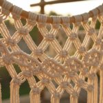 Extreme close-up detail of a handmade macrame hammock, intricate knotted natural cotton rope pattern