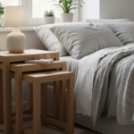 A set of three wooden nesting tables of varied heights arranged together in a Scandinavian-style bed