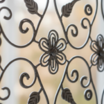 Macro close-up detail of a steel wire fence handcrafted with lace-like floral pattern, intricate met