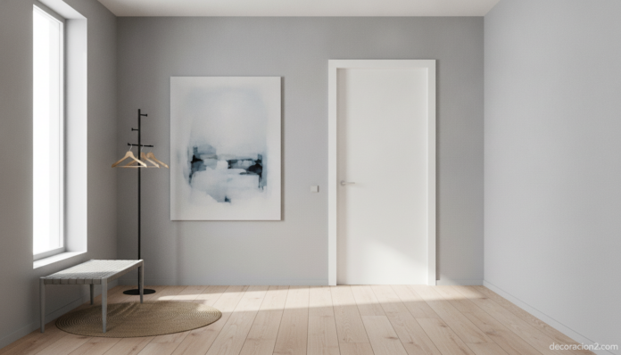 Wide interior architecture photo of a modern minimalist entrance hallway with a flush, frameless door in matte white, clea... Puerta minimalista blanca en un pasillo moderno de líneas puras